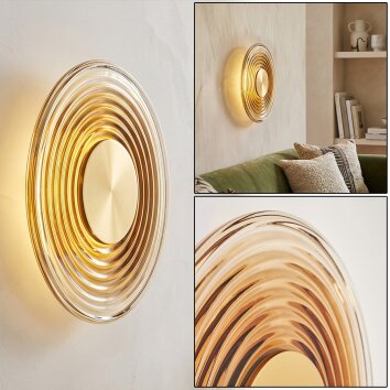Aplique LED Liriel con anillos metálicos en latón, 3000 Kelvin de luz cálida junto al sofá